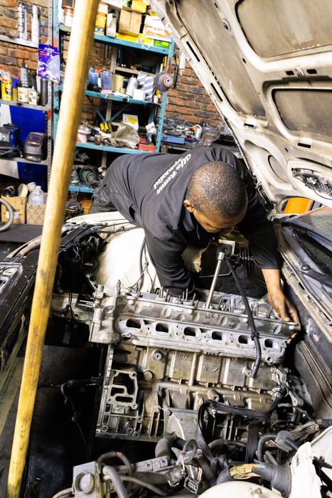 A technician working on a stripped engine
