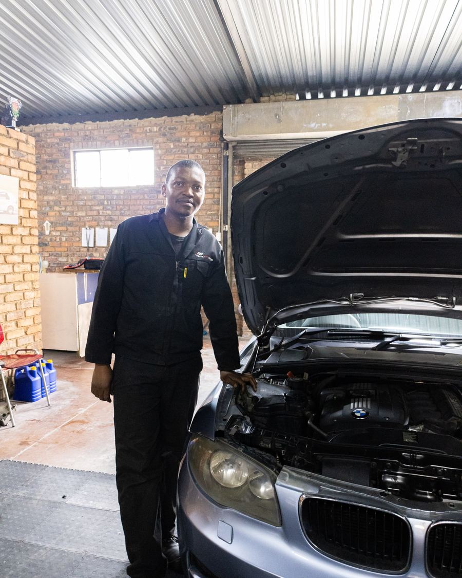 A CRS Auto technician standing proudly beside a BMW