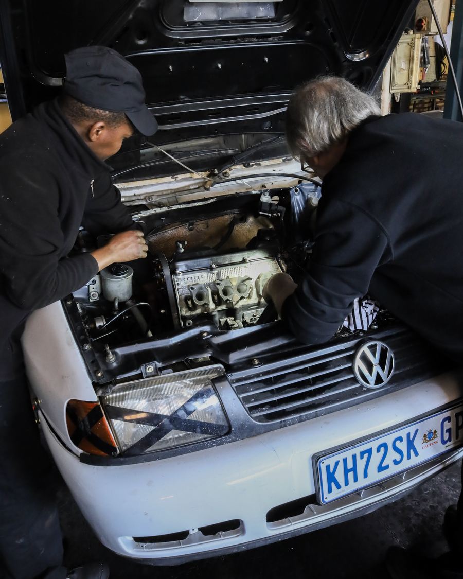 Two CRS Auto technicians working together in an engine bay